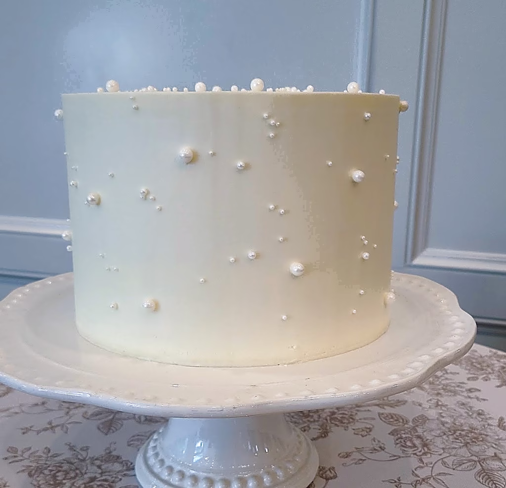 Minimalist white buttercream wedding cake with delicate dots